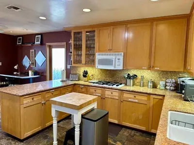 a kitchen with wooden cabinets and a stove top oven at Cheerful Single Story 3-bedroom home w pool table in Santa Clarita