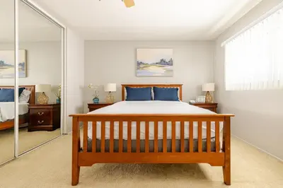 a bedroom with a bed and a large mirror at Steps to Ocean Bliss in Long Beach