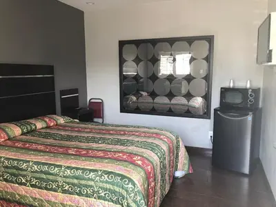 a hotel room with a bed and a television at El Grande Motel in South Gate