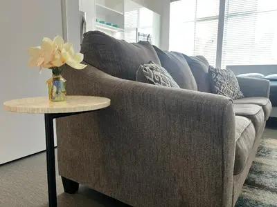 a gray couch with a vase of flowers on a table at The NoHo Artist Nook in Burbank