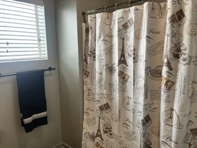 a bathroom with a shower curtain and a window at The NoHo Artist Nook in Burbank