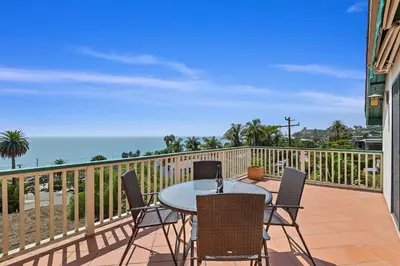 a balcony with a table and chairs and the ocean at Blue Ocean View Retreat - Minutes to Beach in Summerland