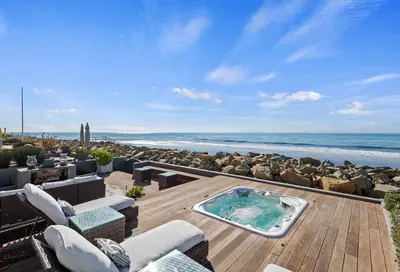 a hot tub on a wooden deck with the beach at Seacliff Beach Retreat - Amazing Beachfront for Family of 6 in Ventura