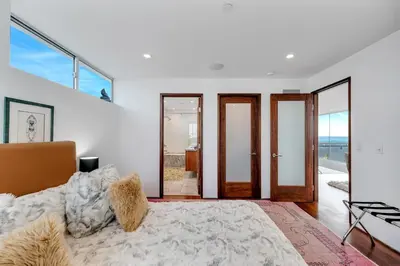 a bedroom with a large bed and glass doors at Modern Ocean Front Beach Home- 3 king beds 3 bedroom in Oxnard