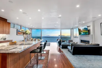 a living room with a bar and a view of the ocean at Modern Ocean Front Beach Home- 3 king beds 3 bedroom in Oxnard