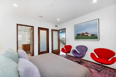 a bedroom with red and purple chairs and a bed at Modern Ocean Front Beach Home- 3 king beds 3 bedroom in Oxnard