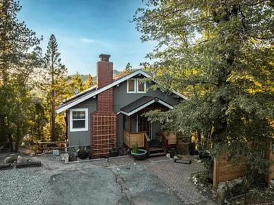 a house in the woods with a driveway at Perch - Peaceful ECO Cedar Hot Tub AC EV Mountain Views in Running Springs