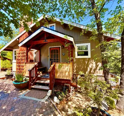 a small house with a porch and a patio at Perch - Peaceful ECO Cedar Hot Tub AC EV Mountain Views in Running Springs