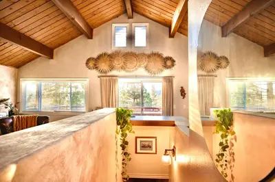 a kitchen with a bar in a house at Perch - Peaceful ECO Cedar Hot Tub AC EV Mountain Views in Running Springs