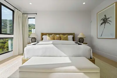 a white bedroom with a large bed and a window at Samara by Stay Awhile Villas in Malibu