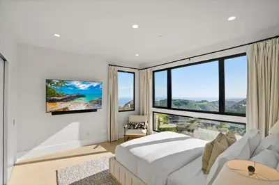 a bedroom with a large bed and large windows at Samara by Stay Awhile Villas in Malibu