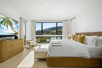a bedroom with a large bed and a large window at Samara by Stay Awhile Villas in Malibu