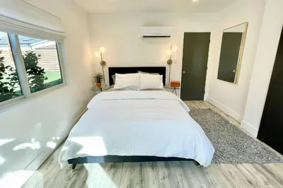 a large white bed in a room with a window at Claudia's Guest House in Los Angeles