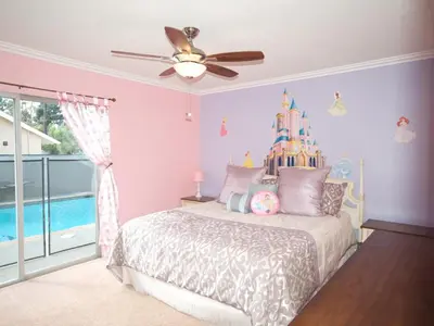 a bedroom with a bed with a disney castle on the wall at F-28 The Wonderland House in Anaheim