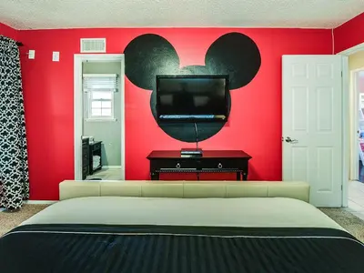 a bedroom with a red wall with a flat screen tv at F-29 The Pirates Cove in Anaheim