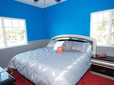 a blue bedroom with a bed with a red alarm clock on it at F-31 Mickeys Beach House in Anaheim
