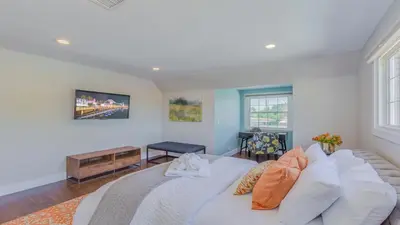 a bedroom with a large white bed and a couch at F-51 Orangewood in Anaheim