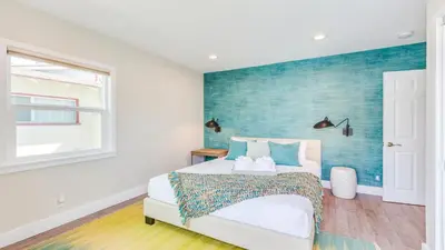 a bedroom with a bed with a blue accent wall at F-52 Trenton II in Anaheim