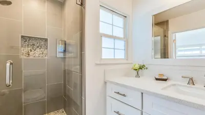 a bathroom with a shower and a sink and a mirror at F-53 Trenton in Anaheim