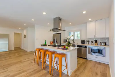 a kitchen with white cabinets and orange bar stools at F-54 Maverick in Anaheim