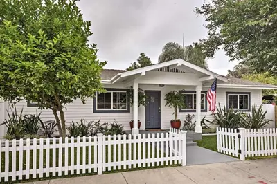 a white house with a fence and an american flag at F-55 Donald Ducks Cottage in Anaheim