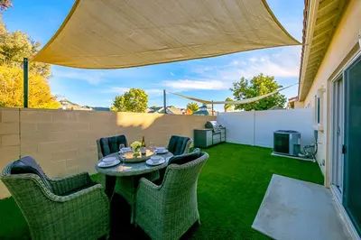 a patio with a table and chairs on the grass at F-56 Winnie the Poohs Treehouse in Anaheim
