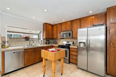 a kitchen with wooden cabinets and a stainless steel refrigerator at F-57 Pride Rock in Anaheim