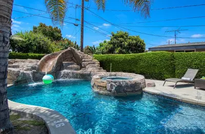 a pool with a water slide in a yard at F-59 Goodhue in Anaheim