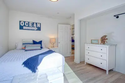 a bedroom with a white bed and a dresser and a mirror at F-64 California Vibes in Anaheim