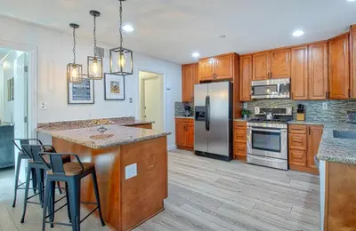 a kitchen with wooden cabinets and a stainless steel refrigerator at F-64 California Vibes in Anaheim