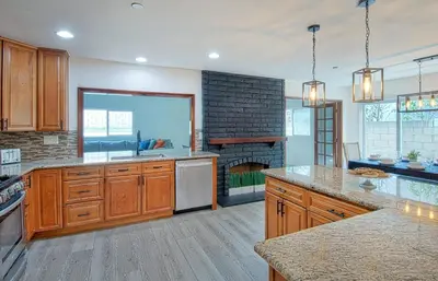 a kitchen with wooden cabinets and a brick fireplace at F-64 California Vibes in Anaheim