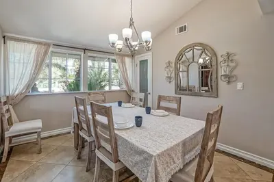 a dining room with a table and chairs and a mirror at F-66 Poolside Retreat in Anaheim