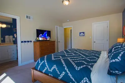 a bedroom with a blue and white bed and a dresser at F-15 Haunted Mansion in Anaheim