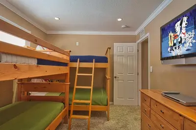 a bedroom with bunk beds and a desk with a laptop at F-20 Paradise Pier in Anaheim