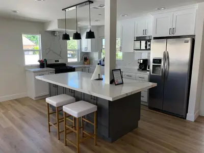 a kitchen with a large island with bar stools and a refrigerator at F-21 Castle House 1 in Anaheim