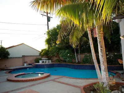 a swimming pool with two palm trees in a yard at F-34 Minnies House in Anaheim