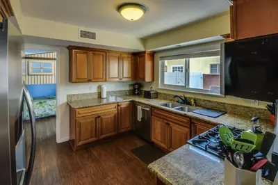 a kitchen with wooden cabinets and a large window at F-30 Small World in Anaheim