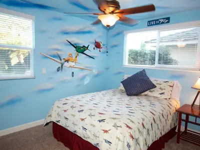 a bedroom with a blue wall with toy planes on it at F-26 Andys House in Anaheim