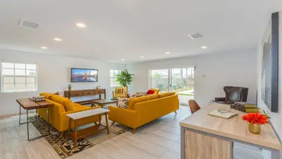a living room with two yellow chairs and a table at F-27 Carnelian in Anaheim