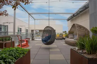 a patio with two swing chairs on a building at Luxury Penthouse 2-BR - with Pool & Gym Access in Los Angeles