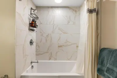 a bathroom with a white tub and a shower curtain at Luxury Penthouse 2-BR - with Pool & Gym Access in Los Angeles