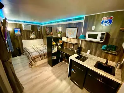 a room with a bed and a desk with a microwave at Cozy Container in Devore Heights, California, for Glamping Getaways on Route 66 in Devore Heights
