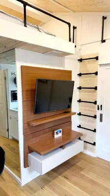 a living room with a tv in a tiny house at Tiny House Living with In Unit Laundry Steps from Kaiser in Litton Industries Heliport