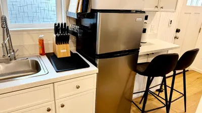 a kitchen with a stainless steel refrigerator and two chairs at Tiny House Living with In Unit Laundry Steps from Kaiser in Litton Industries Heliport