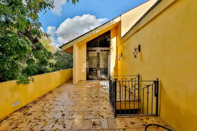 an entrance to a yellow building with a gate at 6BR-Music Studio-Pool-Spa & Games in Sherman Oaks