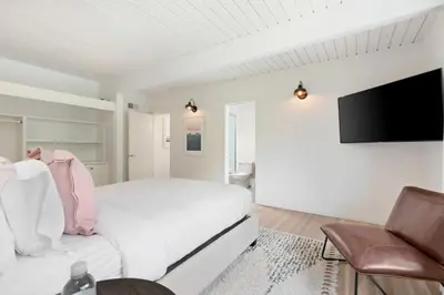 a white bedroom with a bed and a tv at Malibu Reserve by Stay Awhile Villas in Malibu