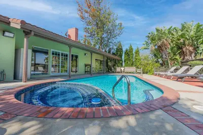 a swimming pool in front of a house at Mulholland Drive with Spa & Game Room in Los Angeles