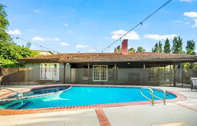 a swimming pool in front of a house at Mulholland Drive with Spa & Game Room in Los Angeles