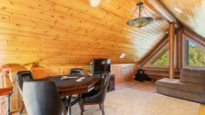 a dining room with a table and chairs in a cabin at Sleeps 27 2 Homes Near the Lake Hot Tub Views Castle Glen Estates in Big Bear Lake