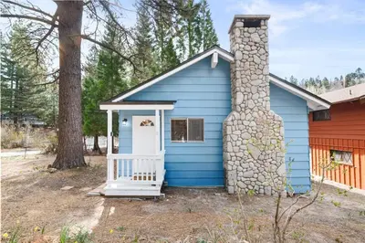 a blue house with a stone chimney at Bluebird Cabin, Indoor Fireplace, Next to Lake! in Green Valley Lake